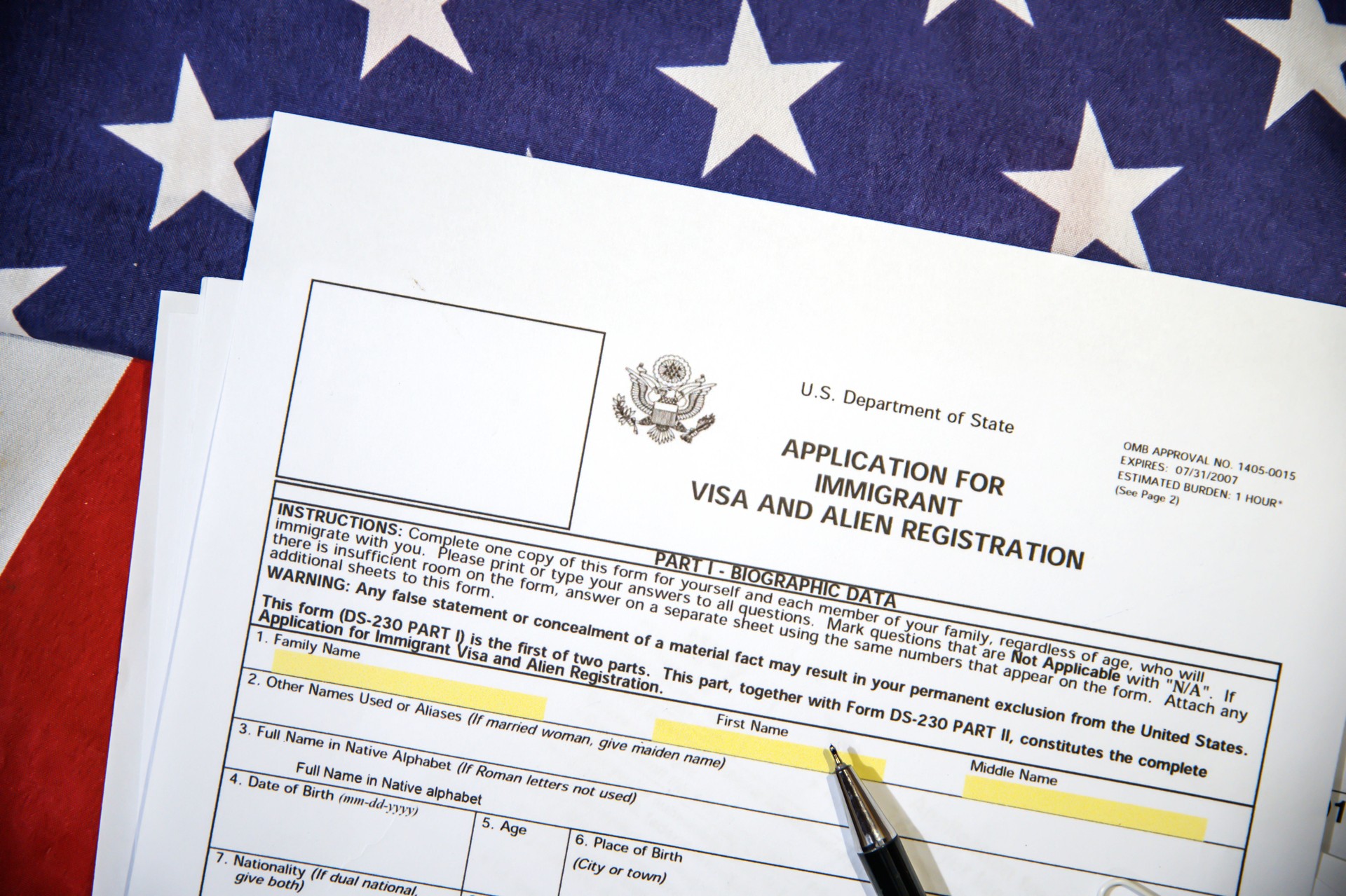 Application form for Immigrant visa and registration with American flag in the backdrop. USA immigrant visa application process background